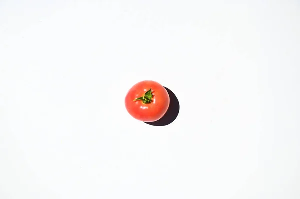 High angle view of a fresh, ripe, juicy red raw tomato isolated on white background with copy ad space for text. Still life. Flay lay. Raw vegan food, Vegetables. Food background