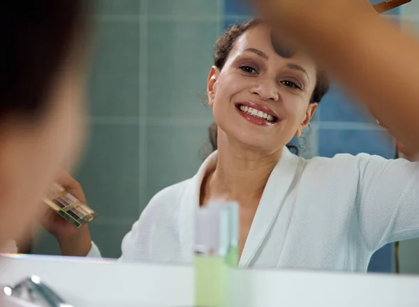 Приємна Приголомшлива Жінка Білому Халаті Відбиваючись Дзеркалі Посміхається Красивій Зубній — стокове фото
