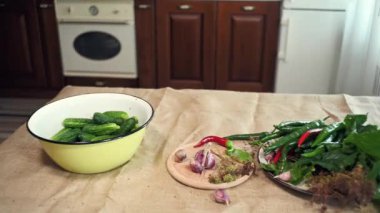 Fresh organic cucumbers, ingredients, and culinary herbs for preparing brine for canning vegetables, on a kitchen table with a linen tablecloth. Pickling. Marinating. Delicacies for the winter