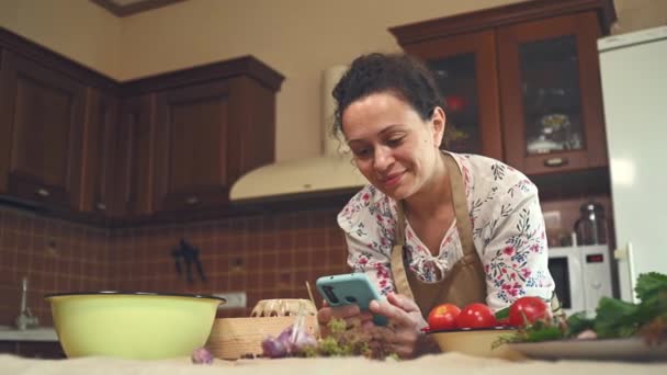 Beautiful Multi Ethnic Woman Apron Using Mobile Phone Looking Recipe — Wideo stockowe