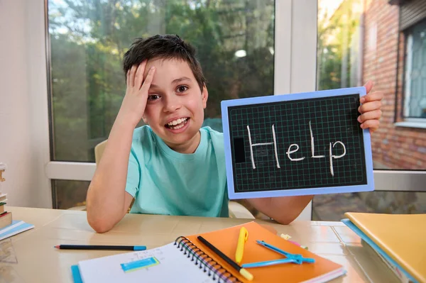 Adorable Puzzled Schoolboy Holds Blackboard Inscription Help Points His Finger — ストック写真