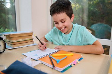 Handsome successful kid, smart elementary school student, school boy doing math and geometry homework. Homeschooling. Opening a new subject in the new semester of the academic year. Back to school