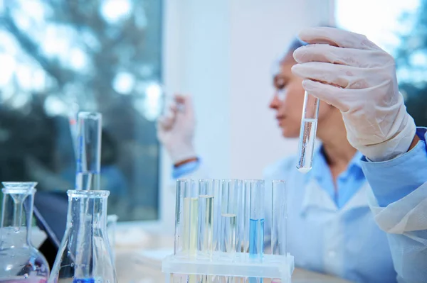 Selective Focus Test Tube Reagent Gloved Hand Blurred Woman Scientist — Foto de Stock