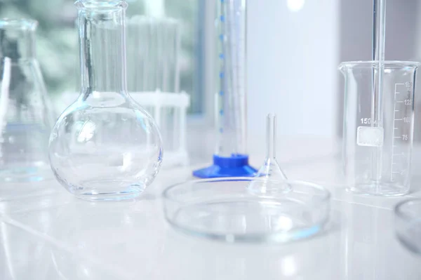 Close-up of empty labware on a white table background in a chemical scientific biological laboratory. Medicine, pharmacy, clinical research, chemistry science