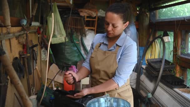 Πολυεθνική Ανθοπώλης Γυναίκα Κηπουρός Μπεζ Ποδιά Στέκεται Ένα Ξύλινο Τραπέζι — Αρχείο Βίντεο