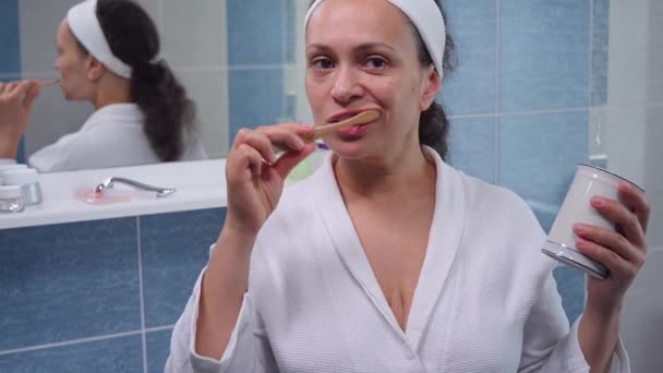 Middle Aged Woman Natural Beauty White Bathrobe Brushing Her Teeth — 图库视频影像