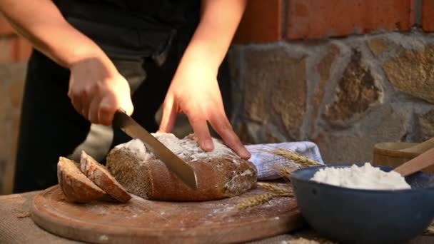 Pekař Pomocí Kuchyňského Nože Krájí Dřevěné Desce Bochník Vícesložkového Žitného — Stock video