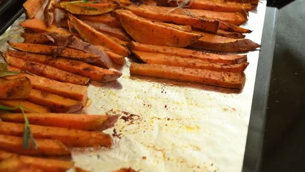 烤红薯片 烤红薯片 淋上橄榄油 洒上香味浓郁的香草和迷迭香叶 放在烤盘上 间歇地集中在一盘素食上 — 图库视频影像