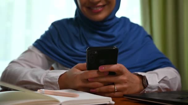 用智能手机 发短信 查看新闻资料 浏览网站等方式 有选择地关注一位穿着蓝色头巾的漂亮的中东穆斯林女性 网上交流 — 图库视频影像