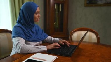 Kendine güvenen güzel bir Arap kadını, başarılı bir perakende müdürü, iş adamı, kafası tesettüre bulanmış bir girişimci, bilgisayarla evden çalışıyor. Modern çağın Orta Doğulu kadını