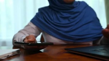 Yakın plan tesettürlü kadın, şarj aletini çıkardı ve telefon görüşmesi kesildikten sonra akıllı telefonunu şarj etti. Cep telefonuna USB kablosu tak, şarj et veya cep telefonuna veri transferi yap