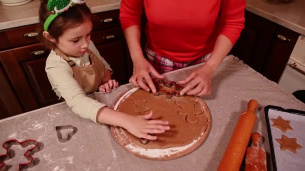 ロールアウト生地から母と娘の切断形状の上からの眺め クリスマスのためのジンジャーブレッドクッキーを準備 幸せな冬の休日の概念 クリスマスの家族の伝統 — ストック動画