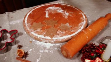 Tahtada yıldız şeklinde zencefilli kurabiye var. Baba ve kızı zencefilli ekmek hamurunu yoğurup sarıyorlar. Noel