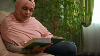 Pembe tesettürlü, kendinden emin, Ortadoğulu Müslüman bir kadın, rahat bir koltukta oturuyor, kitap okumaktan zevk alıyor, haftasonu roman okurken dinleniyor. Boş zaman. Hobi olarak. Edebiyat. Etkinlik