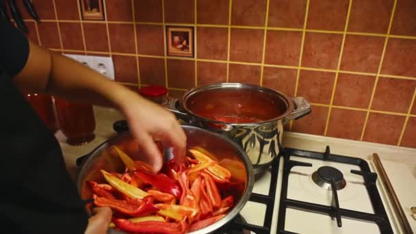 伝統的なレシピによると 甘いピーマンのスライスを沸騰トマトソースと鍋に入れて主婦のクローズアップ 調味料を準備 冬の缶詰ピーマン — ストック動画