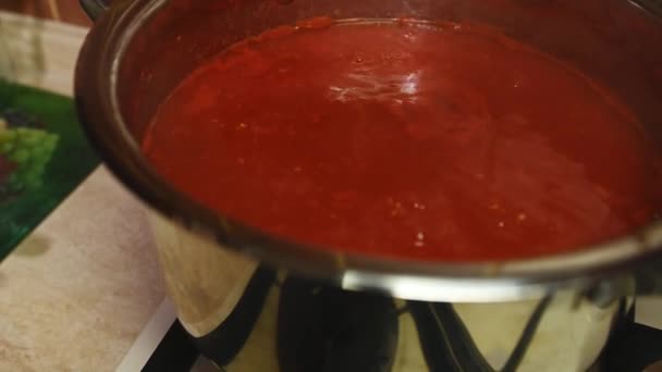 接近中だ 台所のストーブの上の金属鍋で沸騰トマトジュース 自家製トマトソースやパスタを有機栽培の熟したジューシーなトマトから調製します 冬の野菜の缶詰 — ストック動画