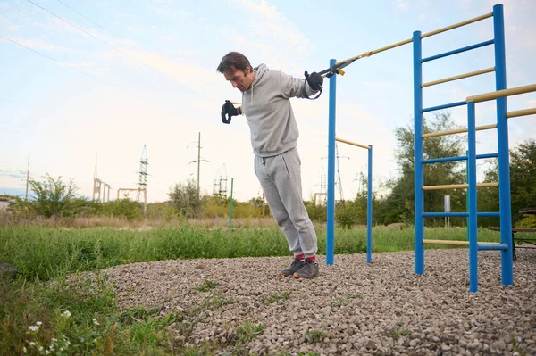 Αποφασισμένος Αρσενικό Αθλητής Εκτελεί Προπόνηση Σωματικού Βάρους Ιμάντες Ανάρτησης Push — Φωτογραφία Αρχείου