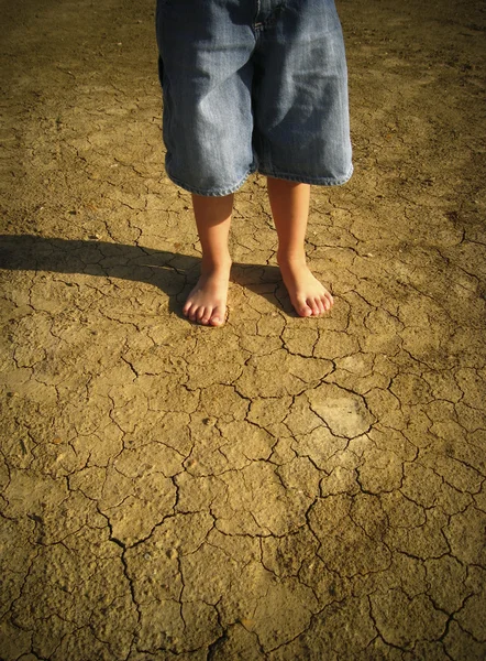 Little boy standing in desert — Stock Photo, Image