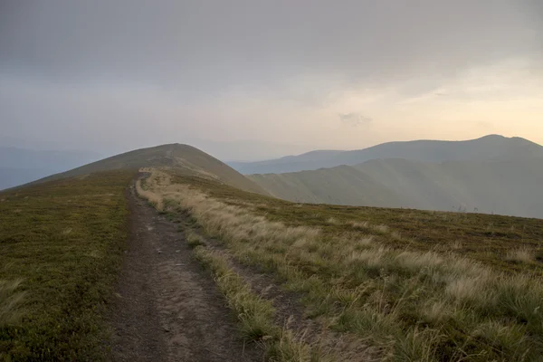 Vejen langs højderyggen ved solnedgang - Stock-foto