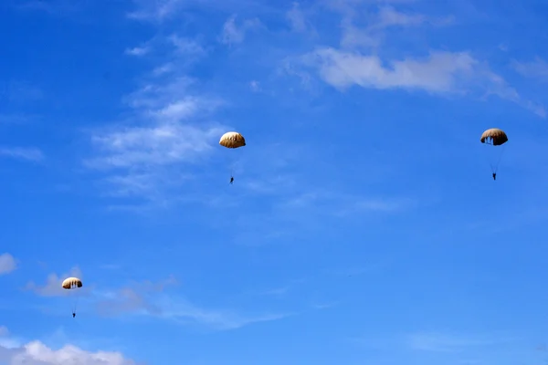 Drie parachutist neer op oude witte parachutes — Stockfoto