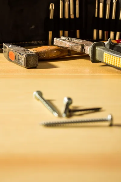 Parafusos e martelo em uma mesa — Fotografia de Stock