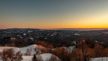 Slovenya ile İtalya arasındaki tepelerde gün batımı dondurucu bir kış günü