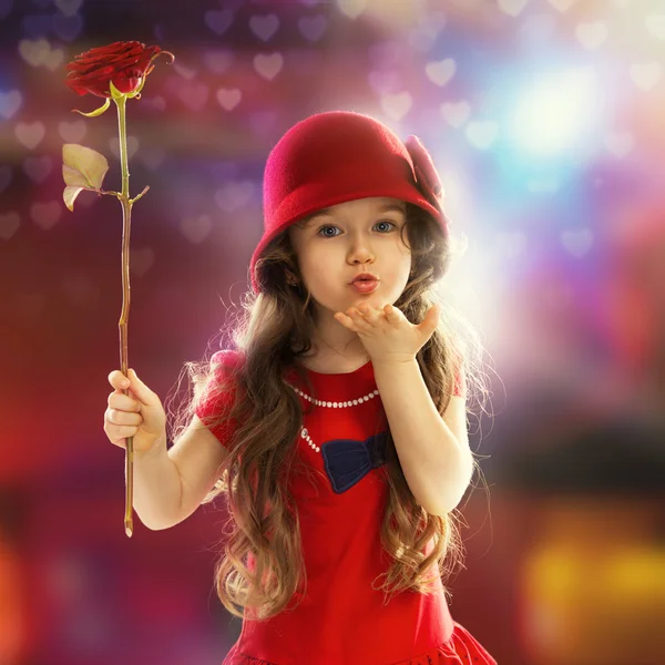 Little girl with rose sends kiss — Stock Photo, Image