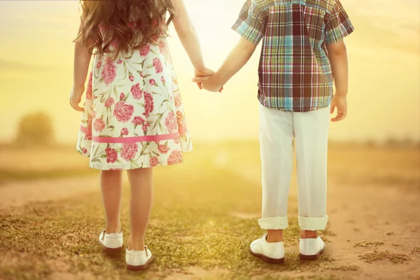 Vista posteriore dei bambini piccoli che si tengono per mano al tramonto — Foto Stock