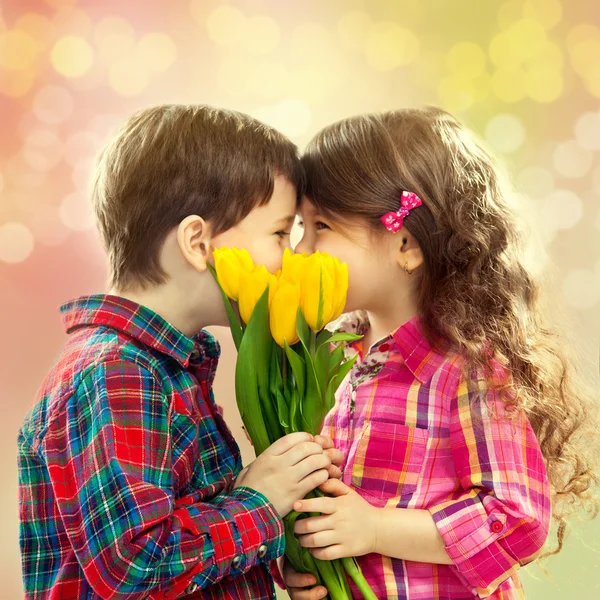 Menino e menina feliz com buquê de flores . — Fotografia de Stock