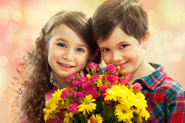 Menino e menina feliz com buquê de flores . — Fotografia de Stock