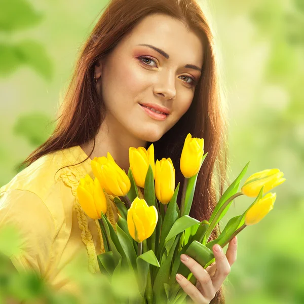 Mooie vrouw met tulpen boeket van bloemen — Stockfoto