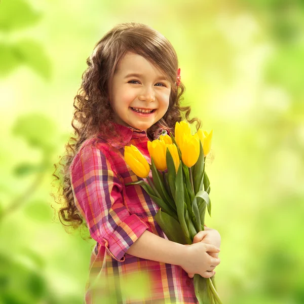 用大束鲜花的小女孩微笑着 — 图库照片