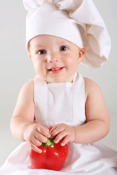 Little baby in a cap chef with Pepper — Stock Photo, Image