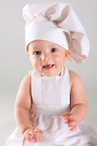 Happy little baby in a cook cap laughs — Stock Photo, Image