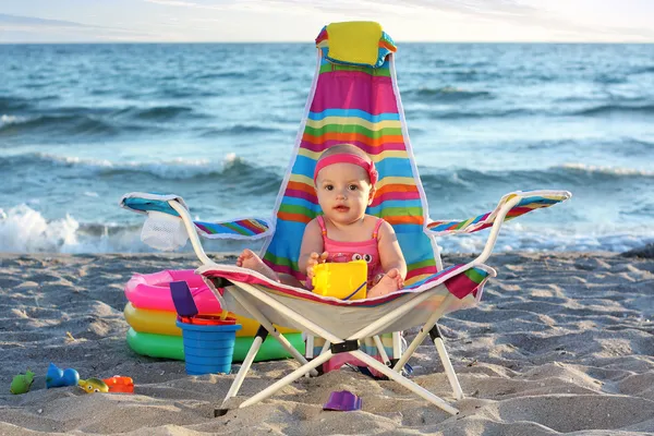 Baby girl on the sand beach with toys — Stock Photo, Image