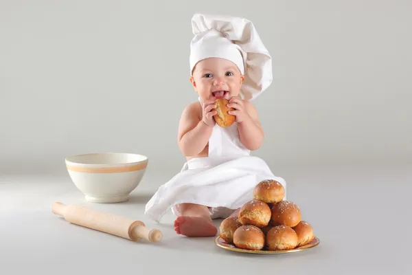 Happy little baby in a cook cap laughs — Stock Photo, Image