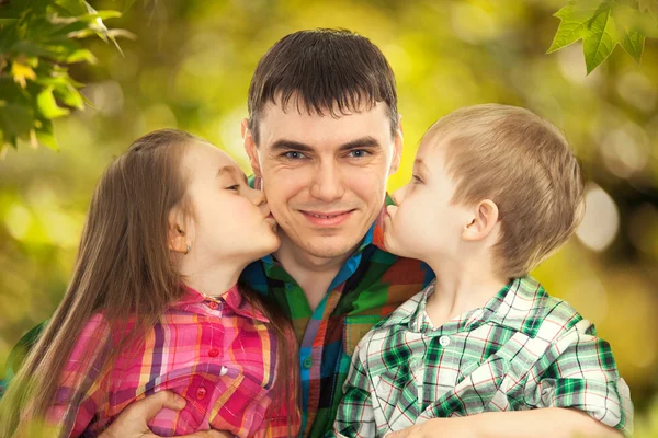 Figlia e figlio baciare padre — Foto Stock