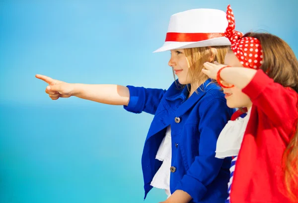 Portrait of fashion kids points to the sea — Stock Photo, Image