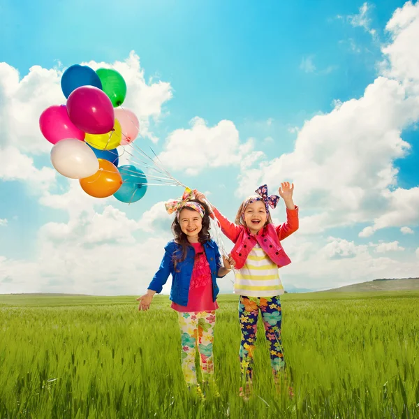 Παιδιά με μπαλόνια περπάτημα στο πεδίο καλοκαίρι — Φωτογραφία Αρχείου