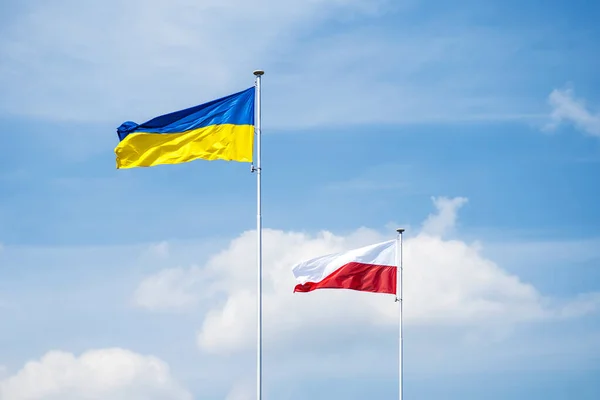 Staatsvlaggen Van Oekraïne Polen Vlaggenmasten Boven Blauwe Bewolkte Hemel Achtergrond — Stockfoto