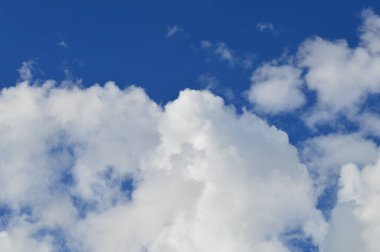 Parlak mavi gökyüzünde yumuşak beyaz bulutlar