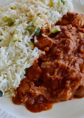 Butter Chicken and rice on a white plate