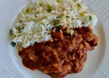 Butter Chicken and rice on a white plate