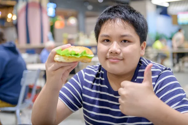 Menino Obeso Gosta Comer Hambúrguer Porco Uma Praça Alimentação Centro — Fotografia de Stock