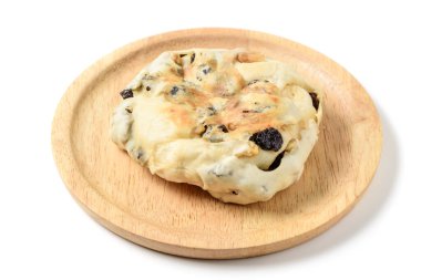 Tahta tabakta krem peynirle doldurulmuş cevizli üzümlü ekmek beyaz arka planda izole edilmiş, ev yapımı fırın konsepti