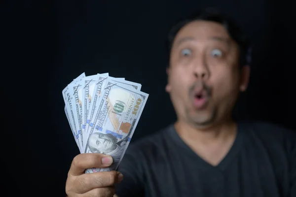 Azji Przystojny Mężczyzna Trzyma Kilka Dolarów Banknoty Czarnym Tle Przestraszony — Zdjęcie stockowe