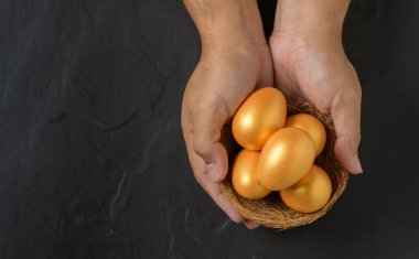 Erkek kuş yuvasında yumurtaları tutar, siyah arka planda, en üstte