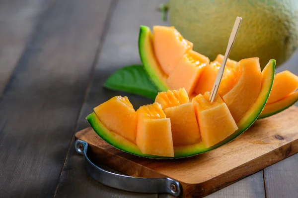 slice of japanese melons, orange melon or cantaloupe melon on wood background, summer fruits