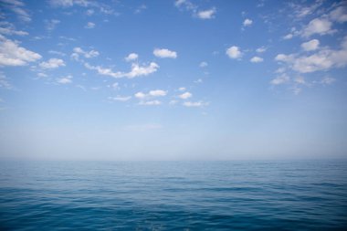 Mavi deniz ve gökyüzü beyaz bulutlarla