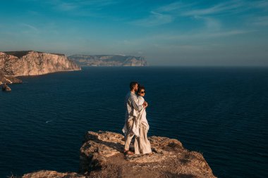 Bir adam, deniz kıyısında güzel bir kadını kucaklıyor. Gün batımında aşık bir çift. Güzel bir çift deniz kenarında gün batımıyla tanışır. Mutlu çift sahilde eğleniyor. Boşluğu kopyala